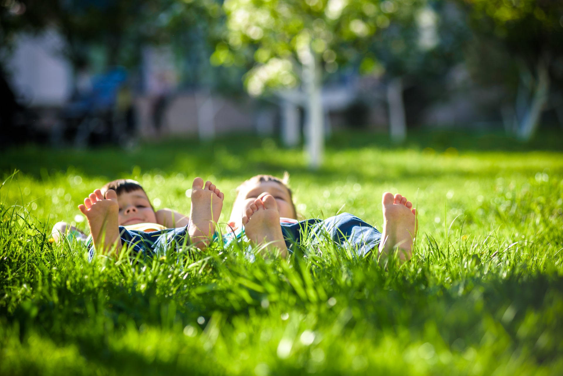 Kinderen liggen met blote voeten in gras